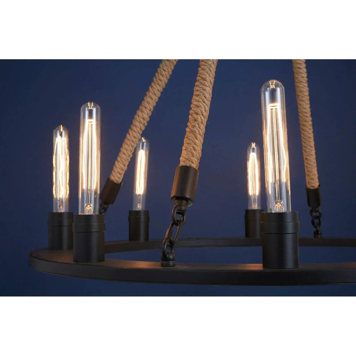 Industrial pendant light with exposed bulbs, rope detail and black metal frame against blue wall