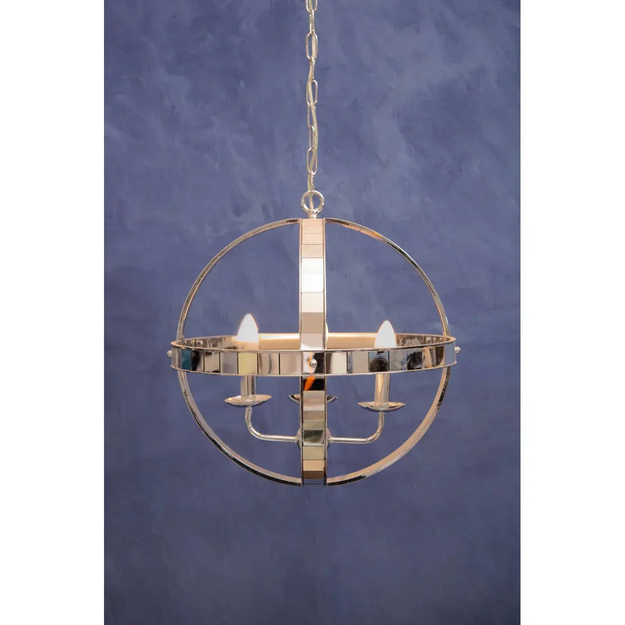 Chrome metal globe pendant light with three bulb holders against blue wall