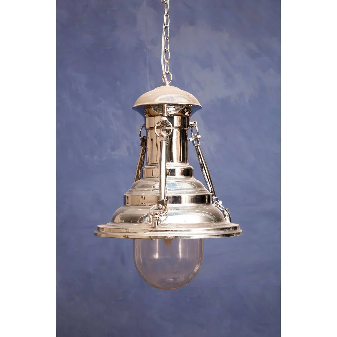 Polished chrome pendant ceiling light with glass shade on chain against blue background