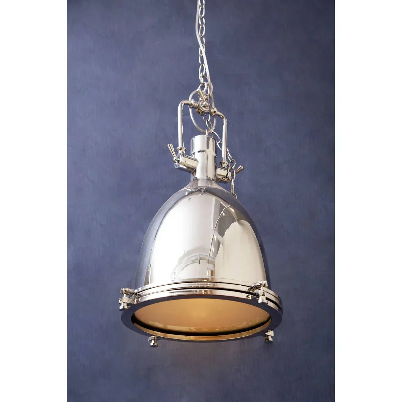 Polished chrome pendant light with industrial design and chain, against blue wall