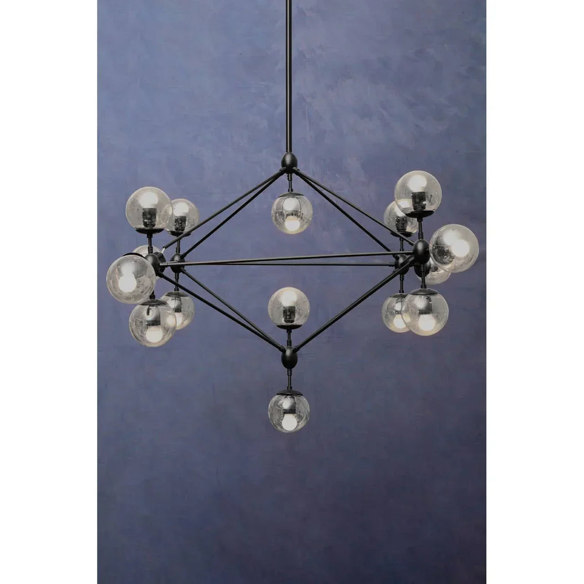 Modern black chandelier with glass globe lights against a blue wall