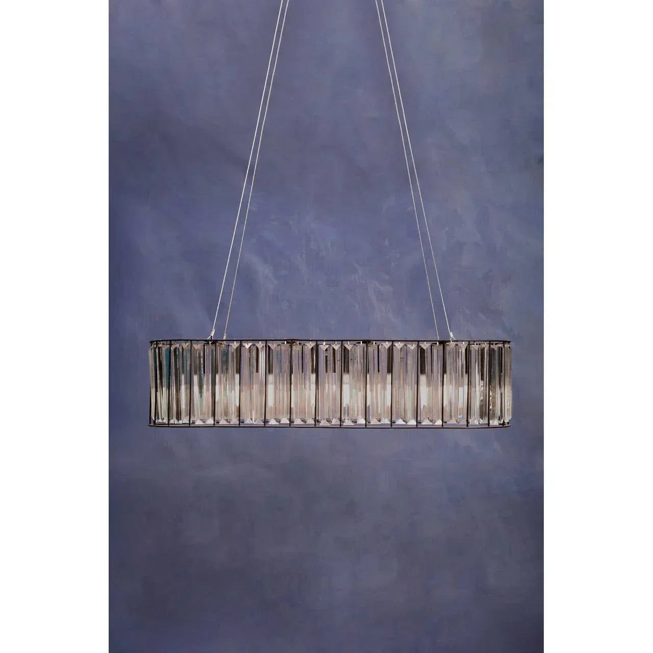 Rectangular crystal pendant light with chrome finish against a blue wall background