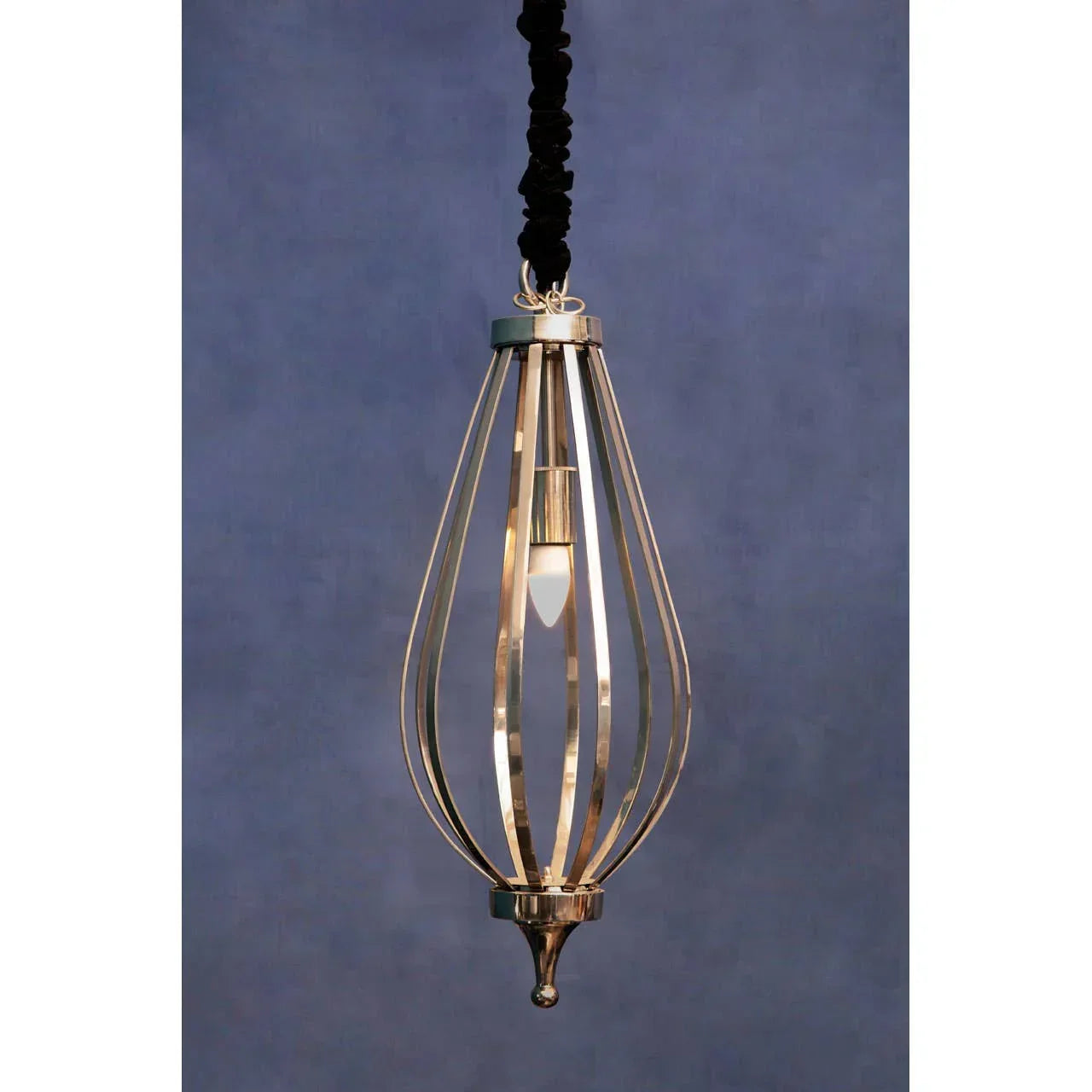 Gold metal pendant light with open cage design and exposed bulb against blue background