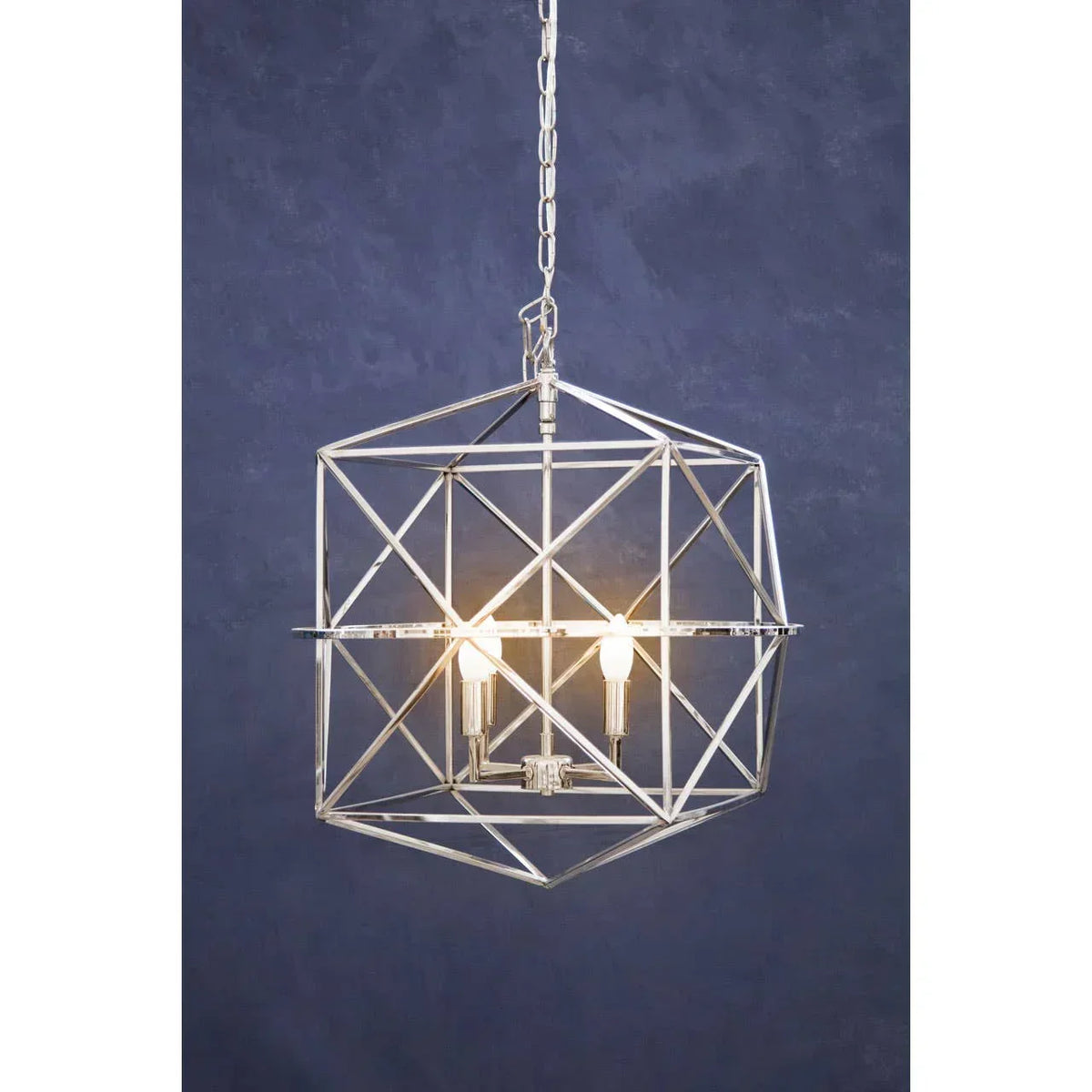 chrome geometric pendant light fixture with exposed bulbs against a dark blue wall