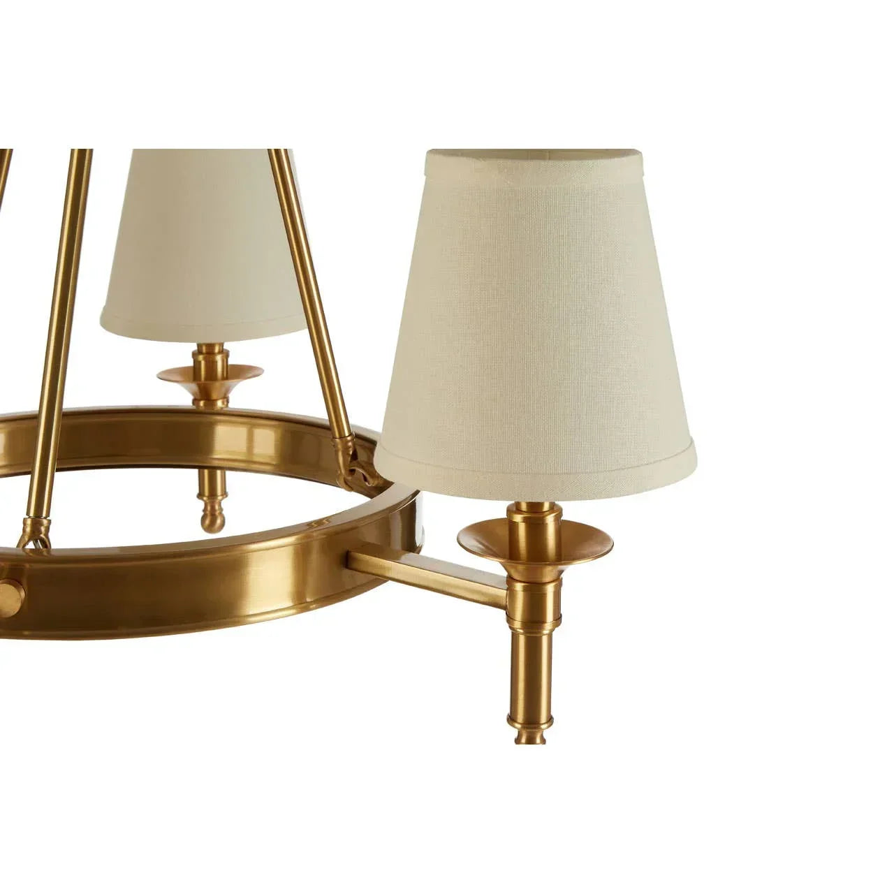 Gold chandelier with cream fabric lamp shades and round metal frame, close-up view