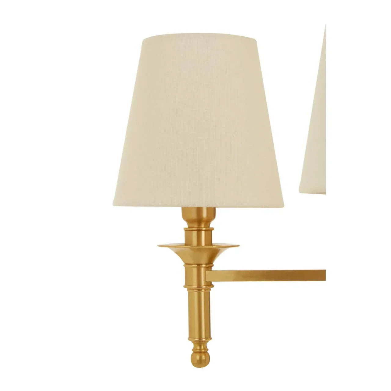 Gold wall lamp with cream fabric shade and classic metal arm, side angle view