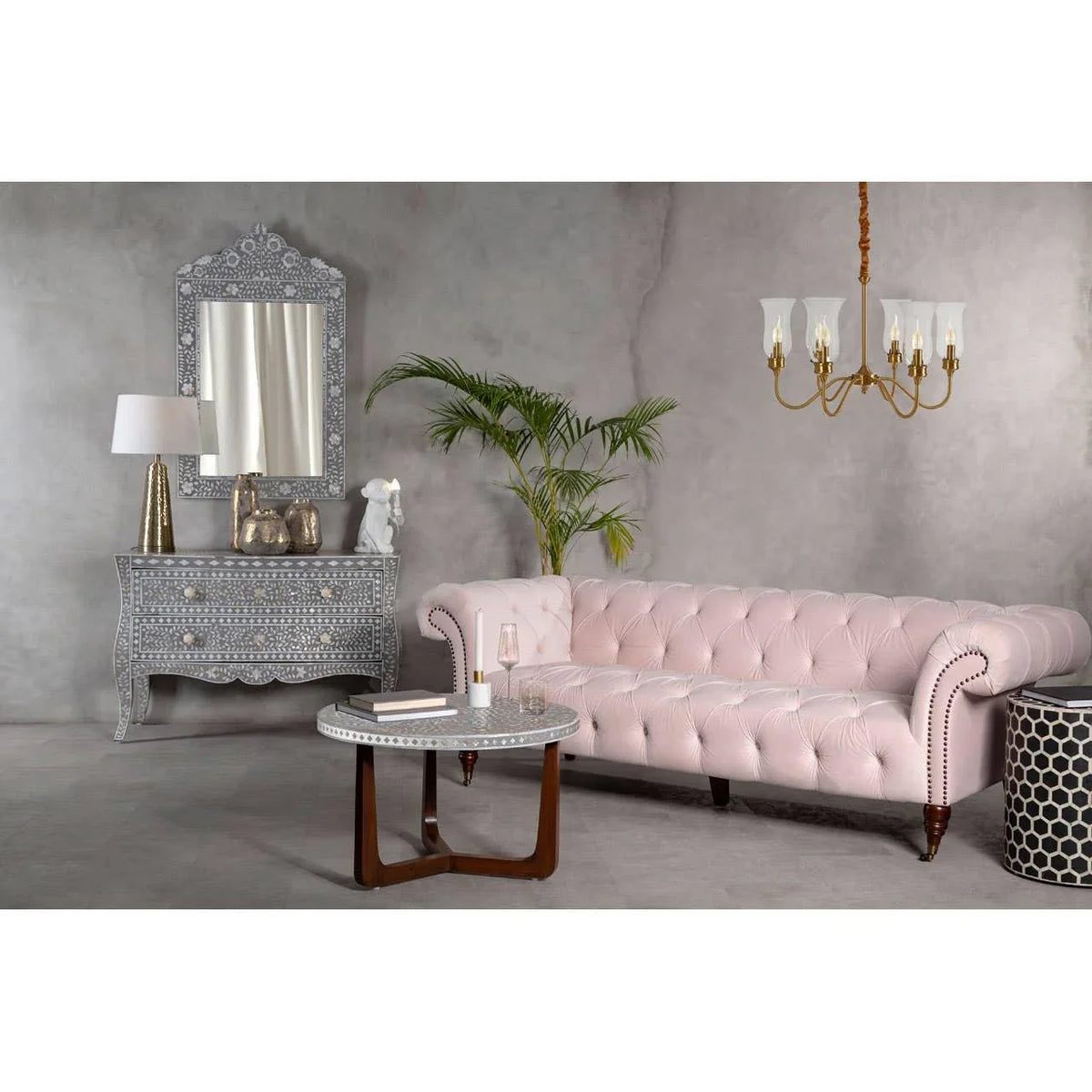 Light pink tufted sofa with round coffee table in modern living room setting