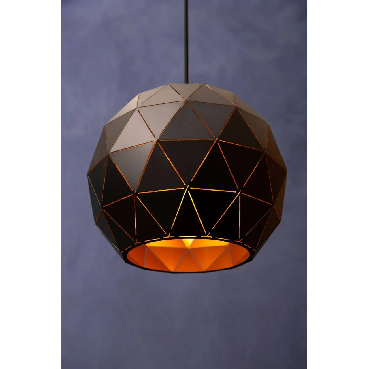 Geometric black pendant light with gold interior against blue wall background