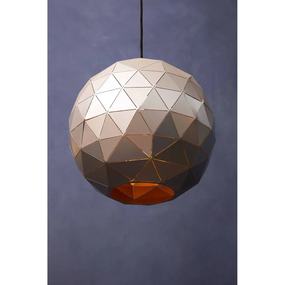Geometric metal pendant light with triangular panels and warm glow against blue background