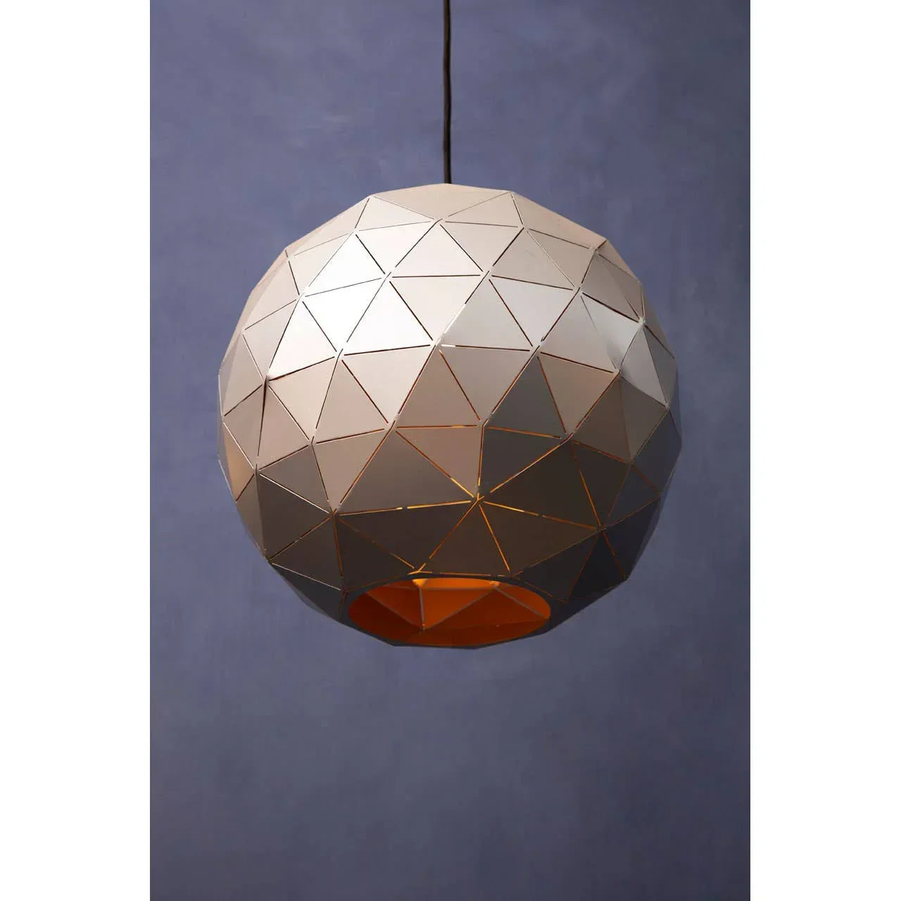Geometric metal pendant light with faceted dome design hanging against blue wall
