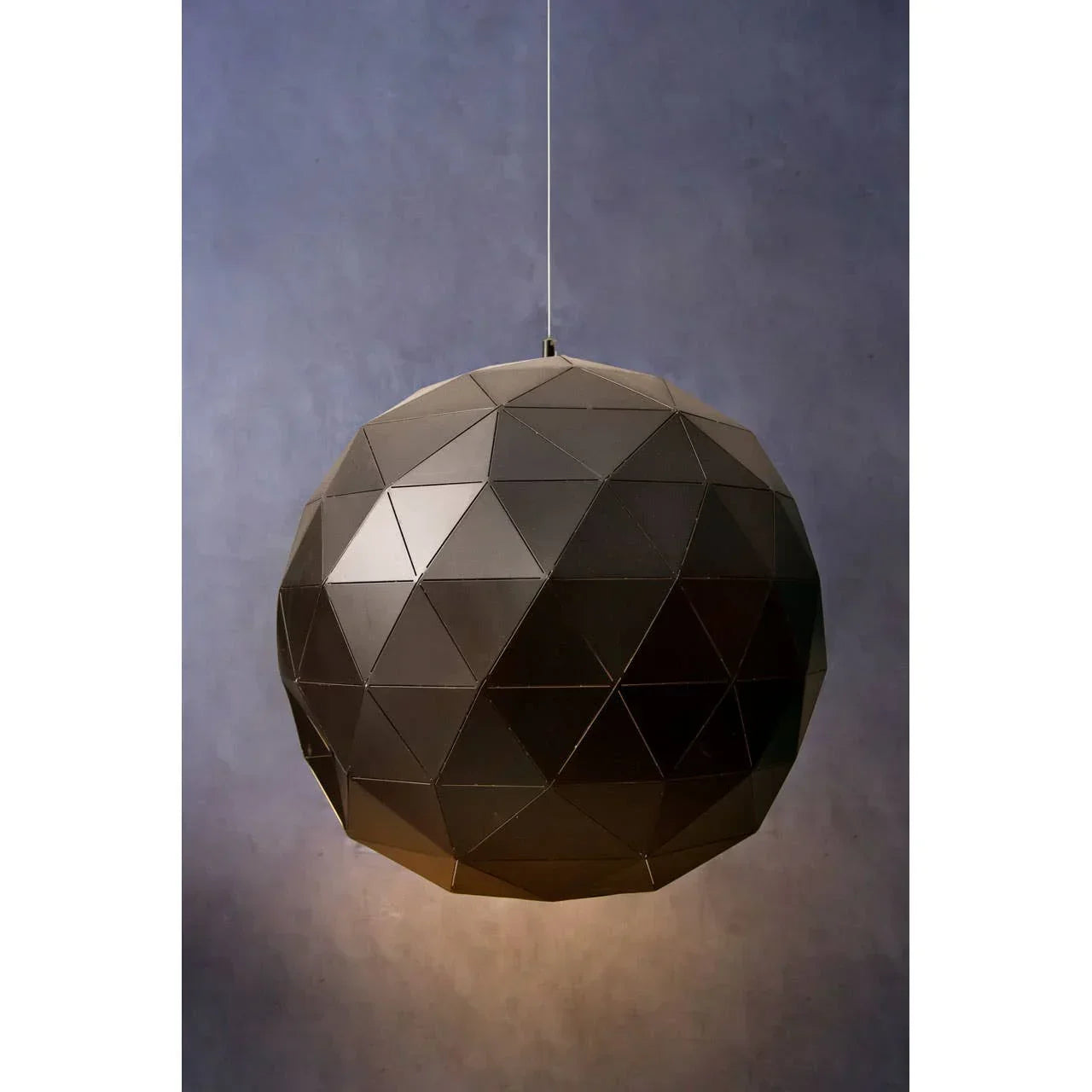 Geometric black pendant light fixture with faceted surface, suspended against a grey background