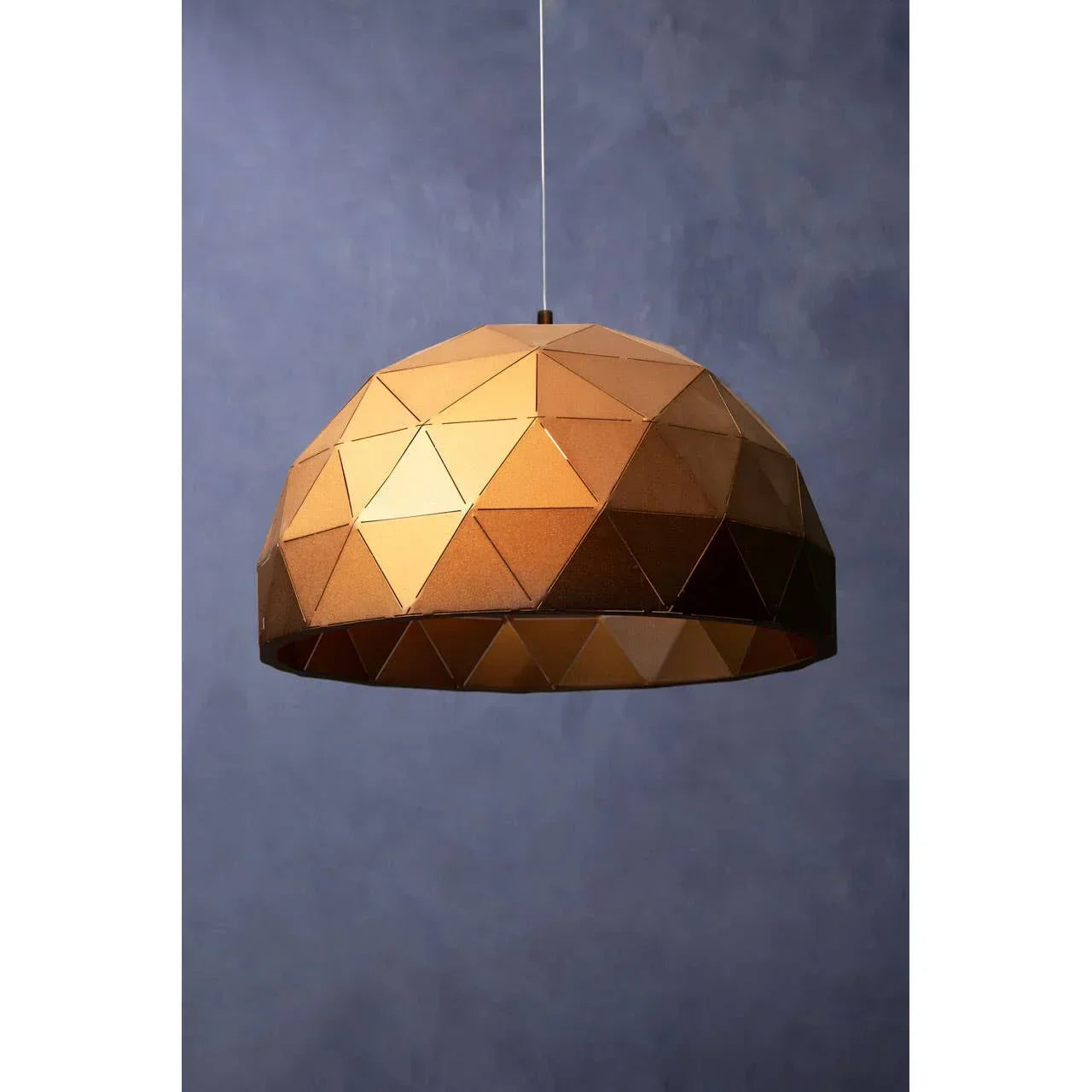 Geometric gold ceiling light pendant with faceted metal shade against blue wall