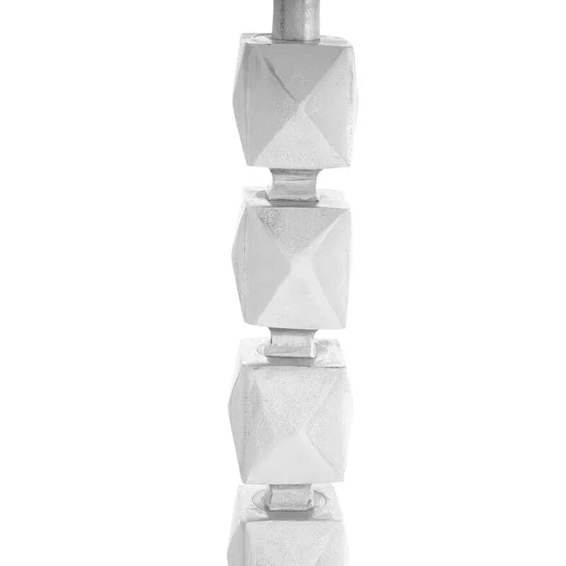 Modern table lamp with stacked geometric silver base and dark shade partial view