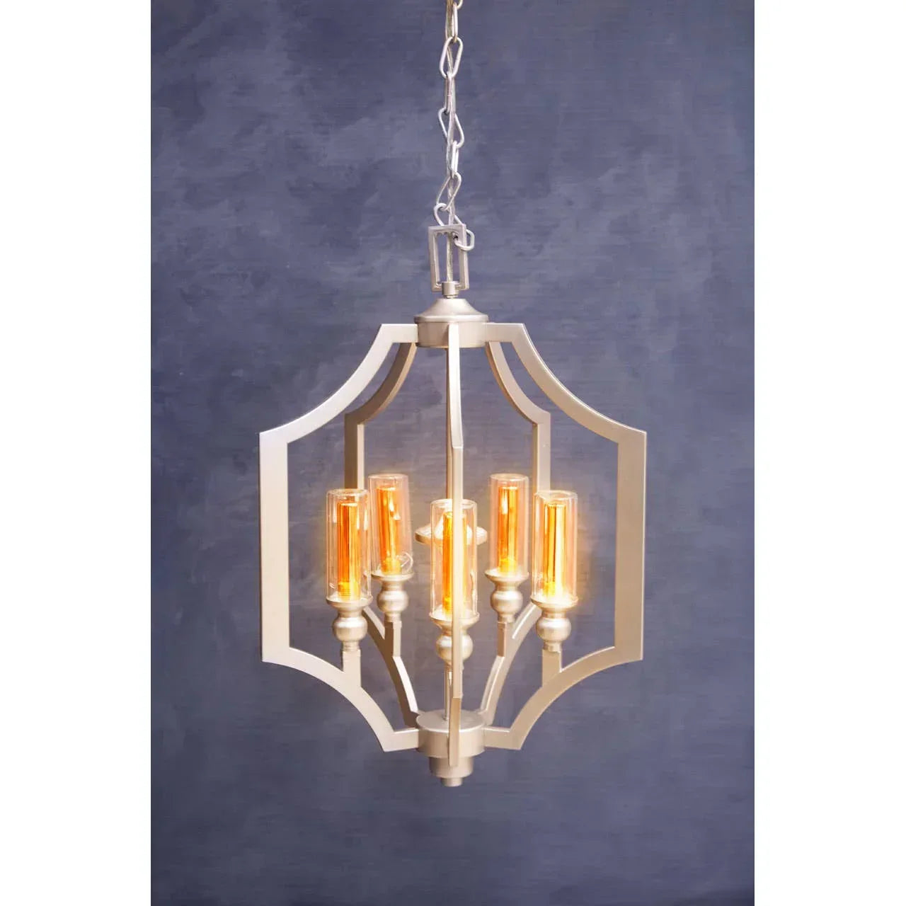 Modern pendant light with gold frame and exposed filament bulbs against a blue background