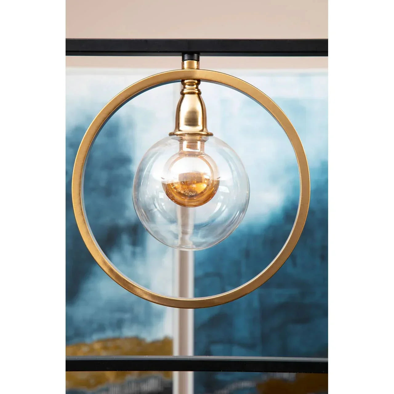 Modern gold pendant light with clear glass globe shade and circular metal frame