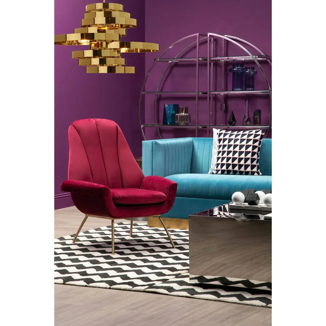 Velvet accent chair in deep red beside blue sofa with patterned cushion in modern living room