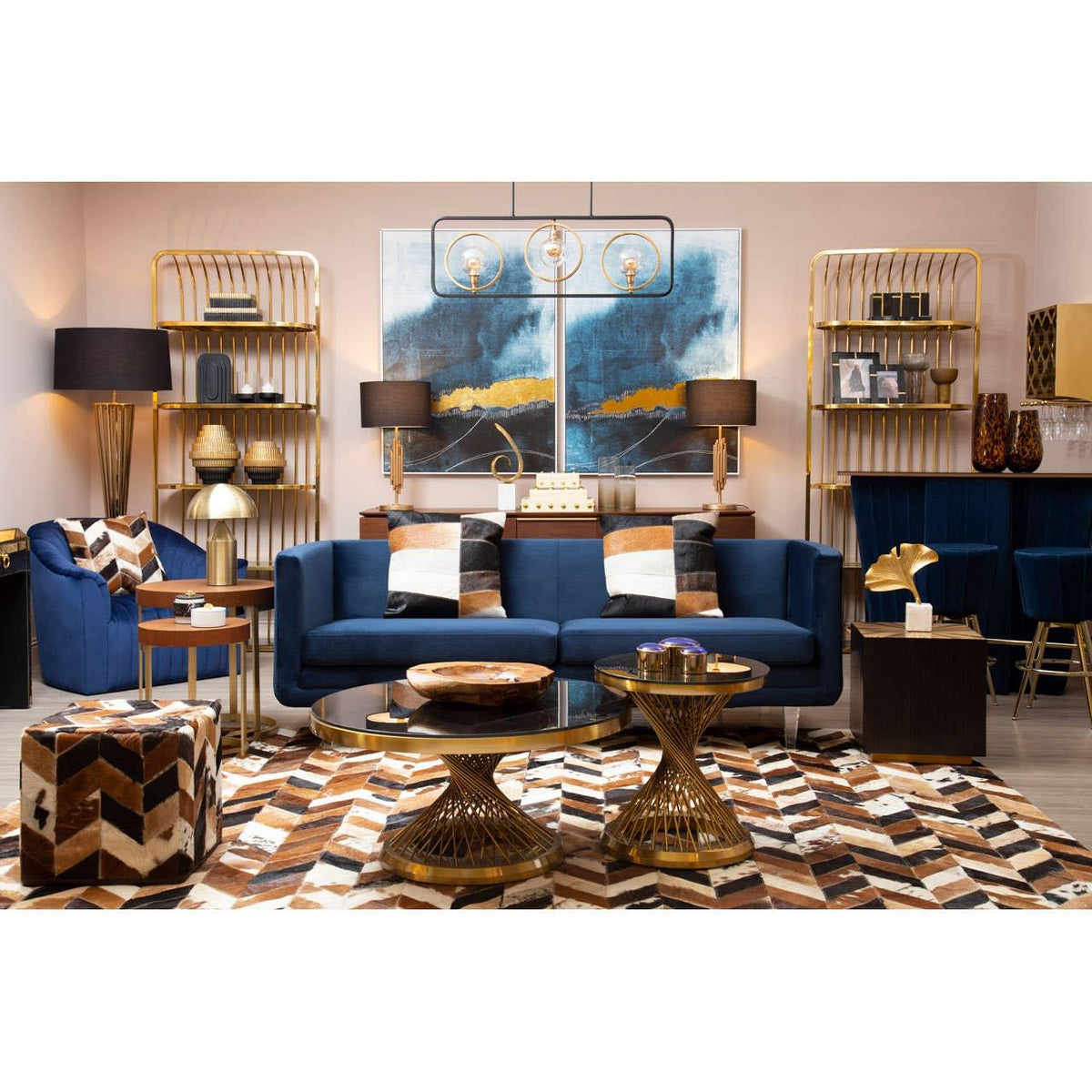 Blue velvet sofa with geometric cushions, gold coffee tables, and shelving in stylish living room