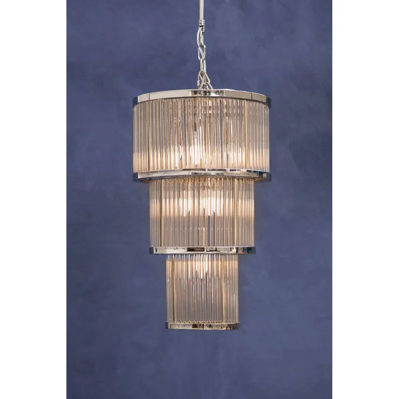 Tiered glass chandelier pendant light with chrome accents on blue background
