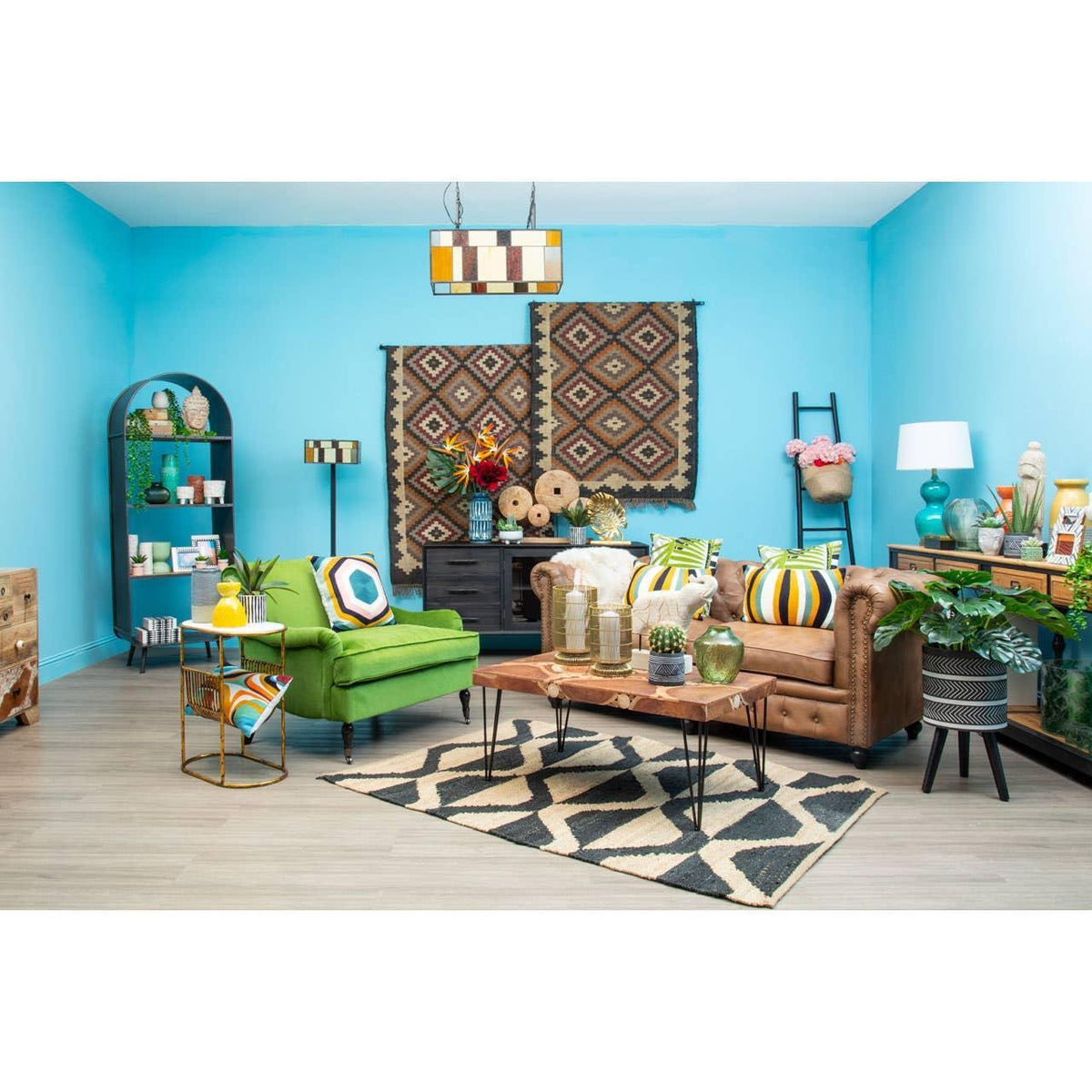 Living room with brown leather sofa, green armchair, geometric rug and blue walls