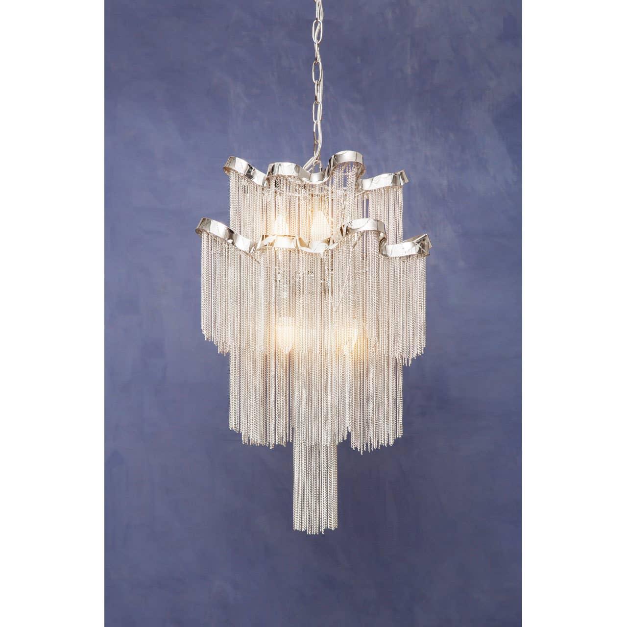 Silver metal chandelier with cascading chain detail against blue wall