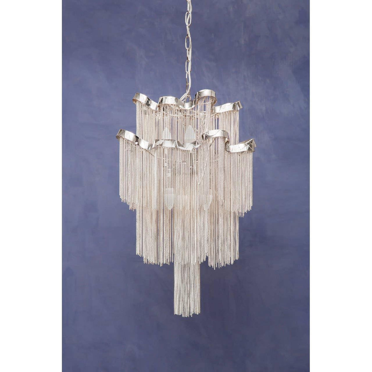 Silver chain chandelier with layered tiers and modern design against blue background