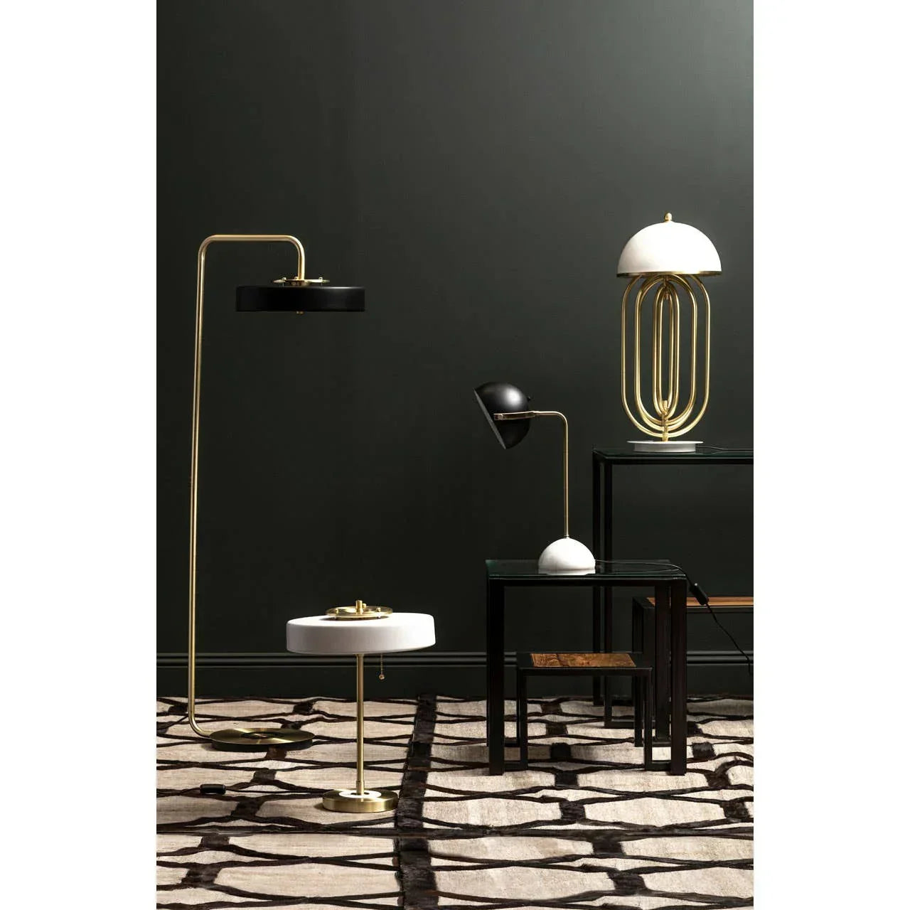 Modern gold and black table lamps and floor lamp with geometric rug and dark wall background