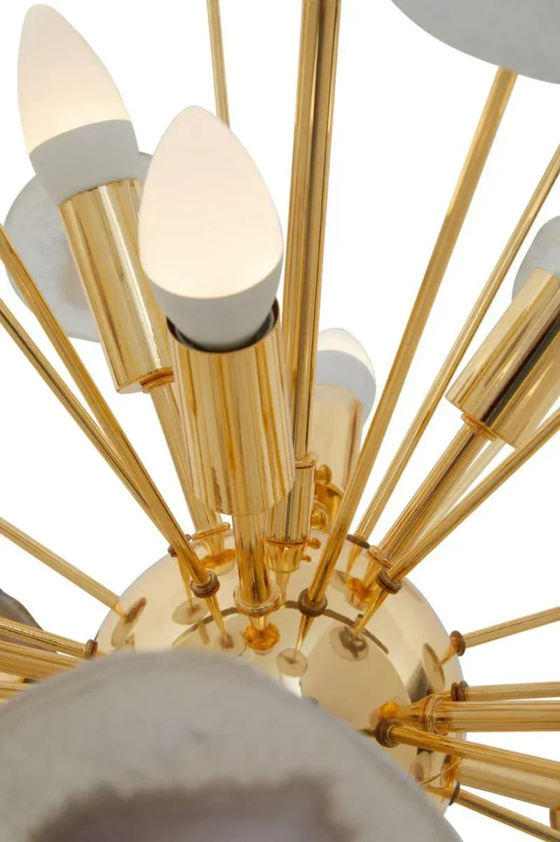 Modern gold chandelier with multiple candle-style bulb fittings and marble accents close-up