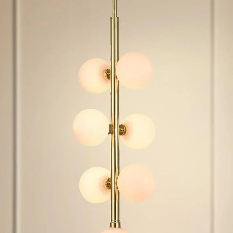 Modern pendant light with six frosted glass globe shades and gold finish, vertical view