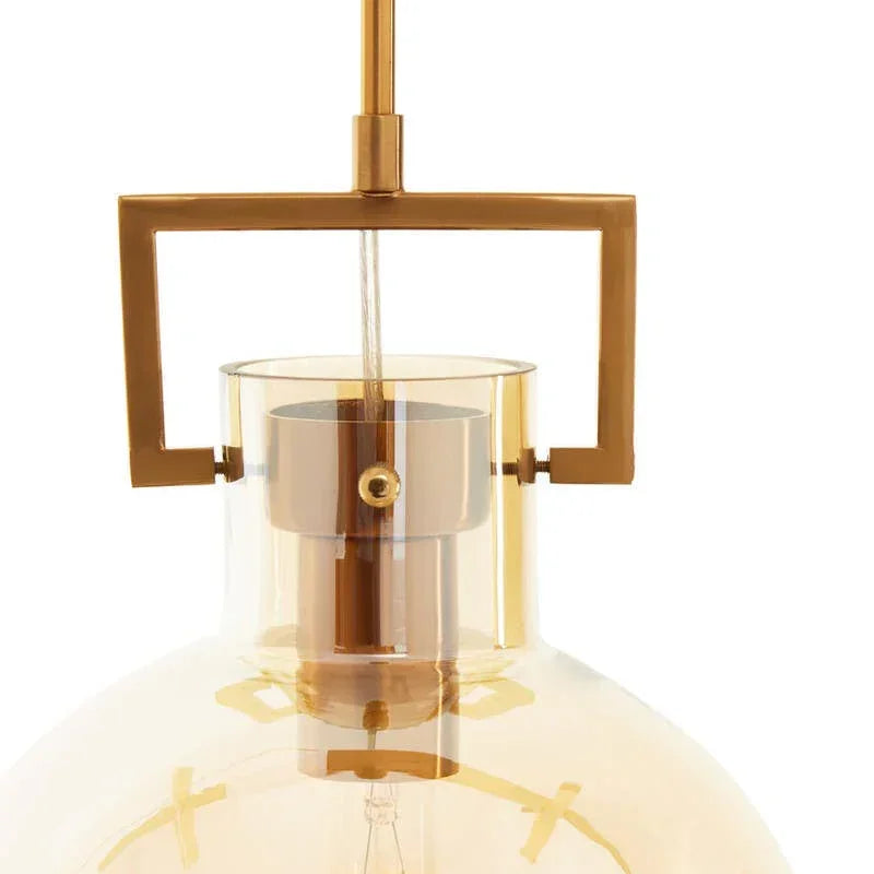 Amber glass pendant light with gold metal frame and exposed bulb, close-up view