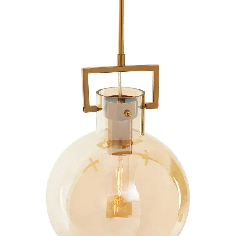 Gold pendant light with round amber glass shade and exposed bulb