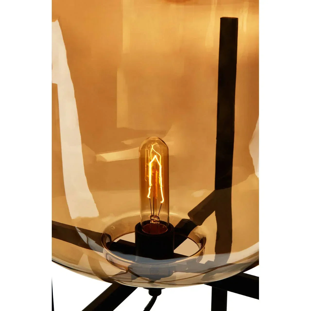 Amber glass table lamp with exposed Edison bulb and black metal base