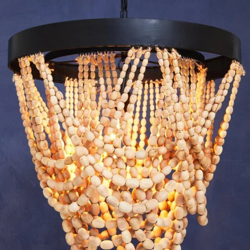Wood bead chandelier with black frame and warm lighting against dark blue wall
