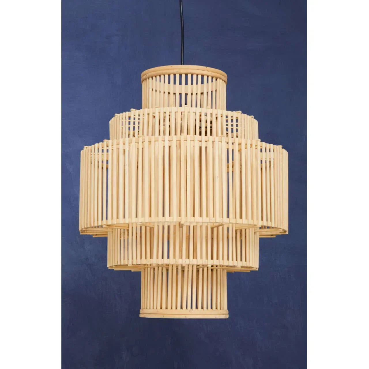Natural bamboo pendant light with tiered cylindrical design against navy wall