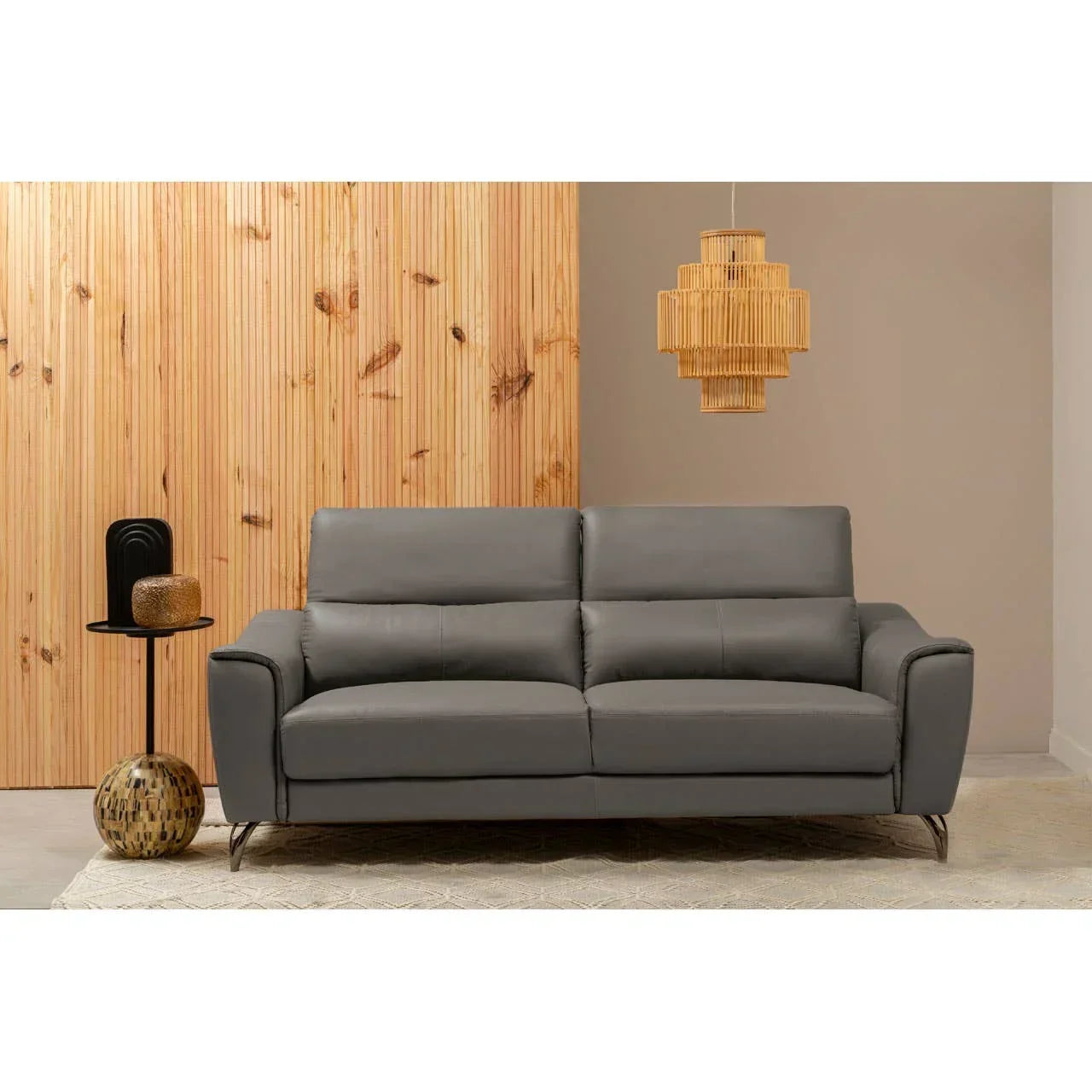 Grey leather sofa with metal legs in modern living room with wooden wall and pendant light
