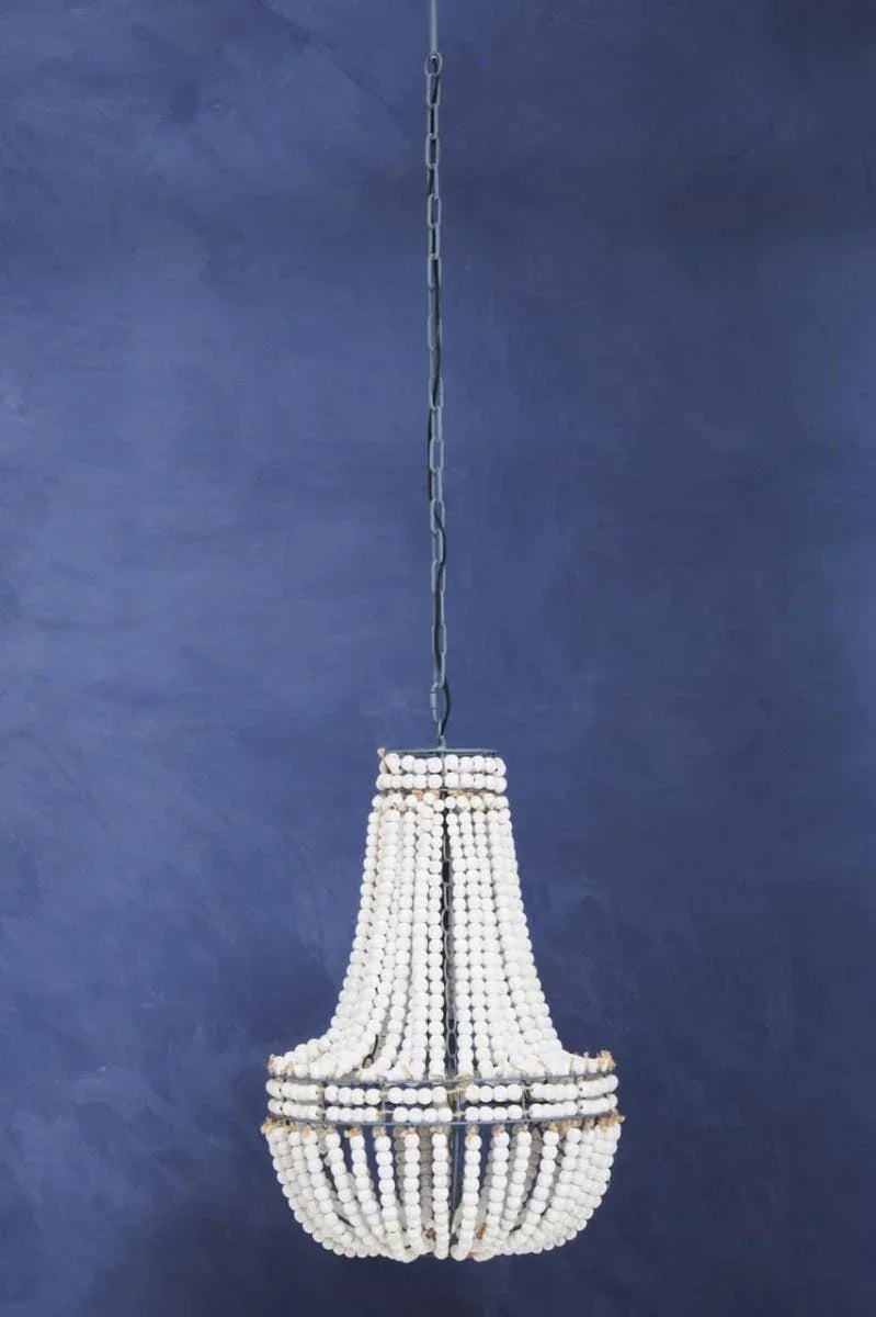 White beaded chandelier with metal frame hanging against a deep blue wall