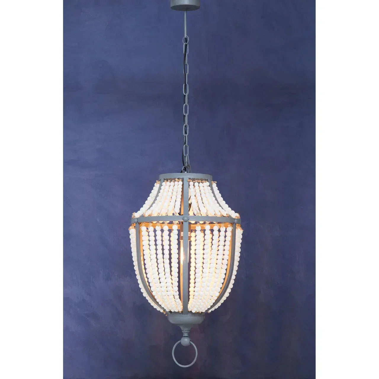 Beaded pendant ceiling light with metal frame against dark blue wall