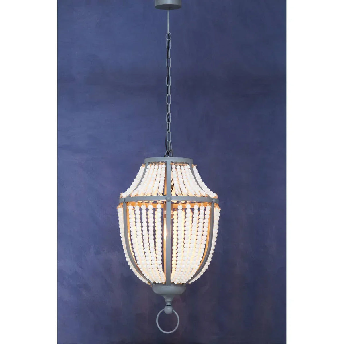 Beaded pendant ceiling light with metal frame against dark blue wall
