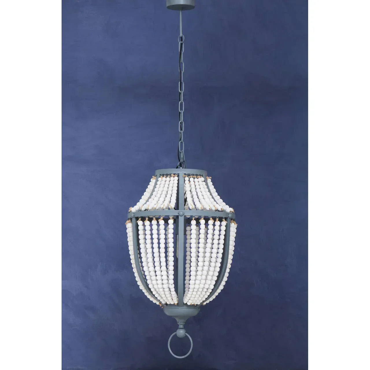 Beaded chandelier pendant light with white wooden beads and dark metal frame against blue wall