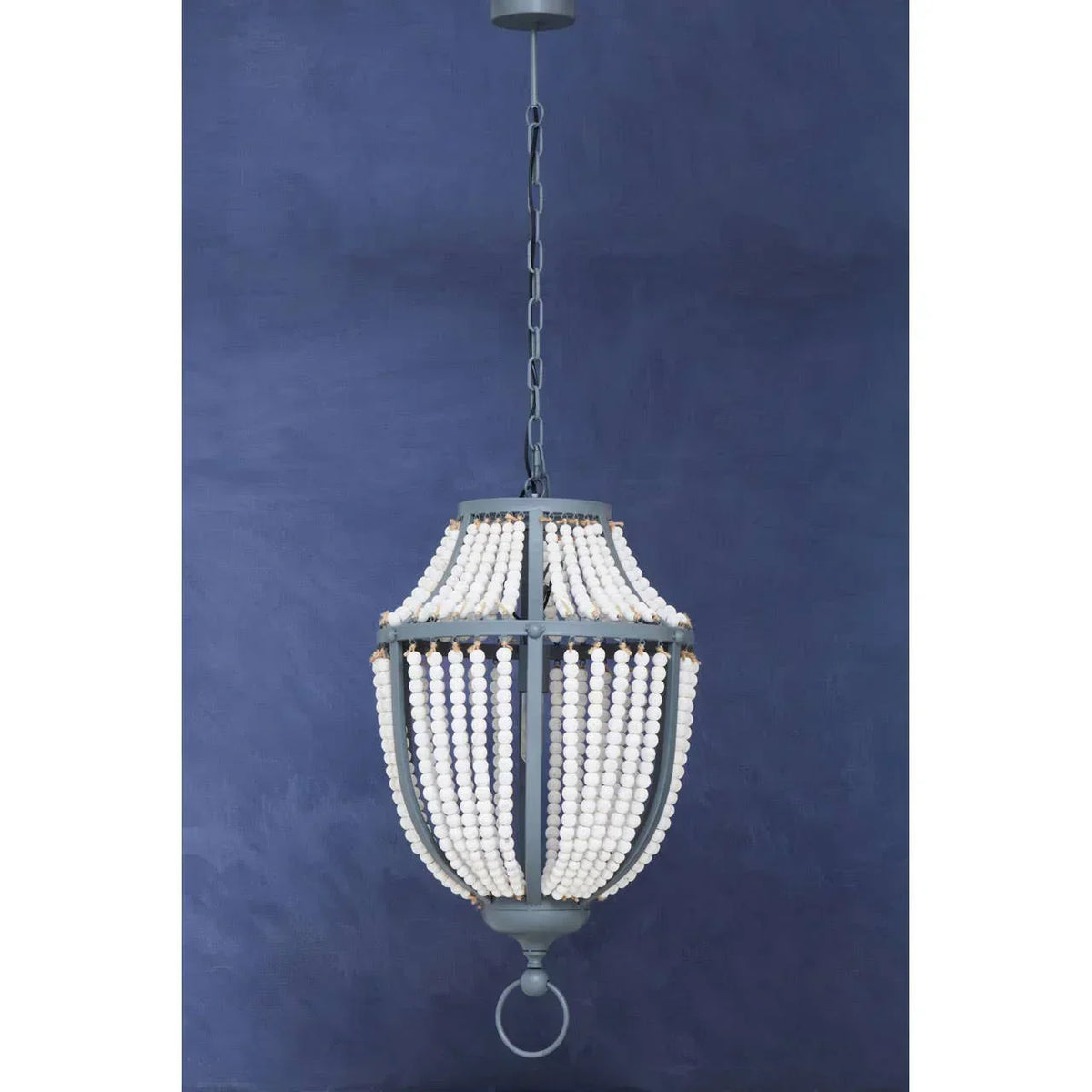 Beaded chandelier pendant light with white wooden beads and dark metal frame against blue wall