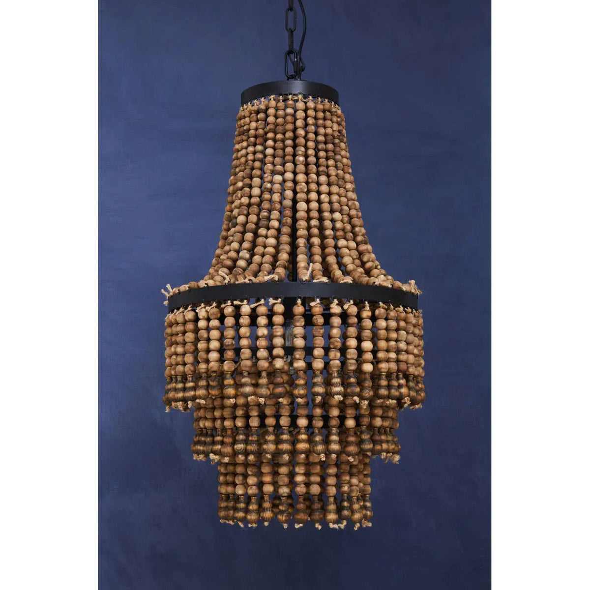 Wooden bead chandelier with tiered design and black metal frame against navy background
