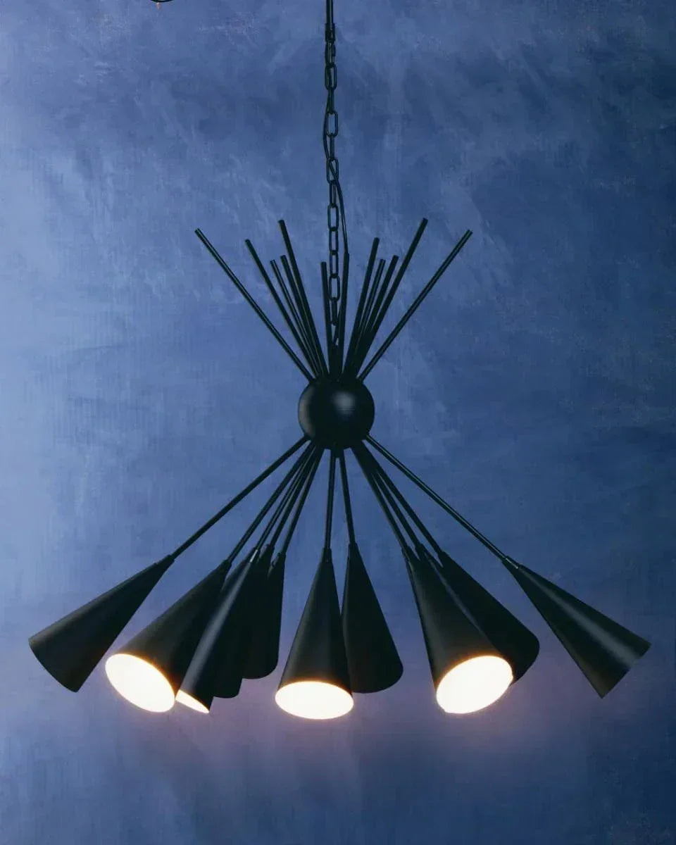 Black metal pendant light with multiple cone shades against a textured blue wall