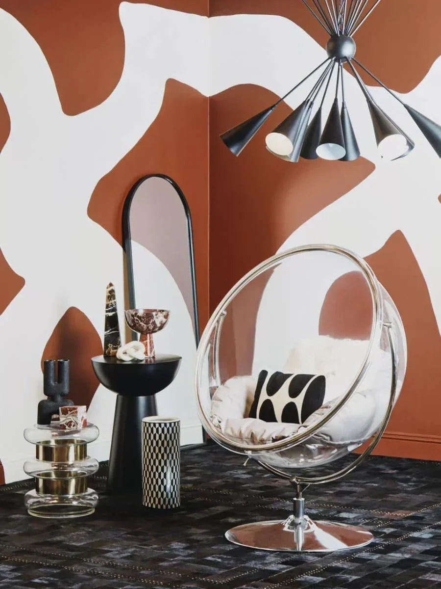 Clear acrylic bubble chair with cushion, modern accent table and geometric decor in living room