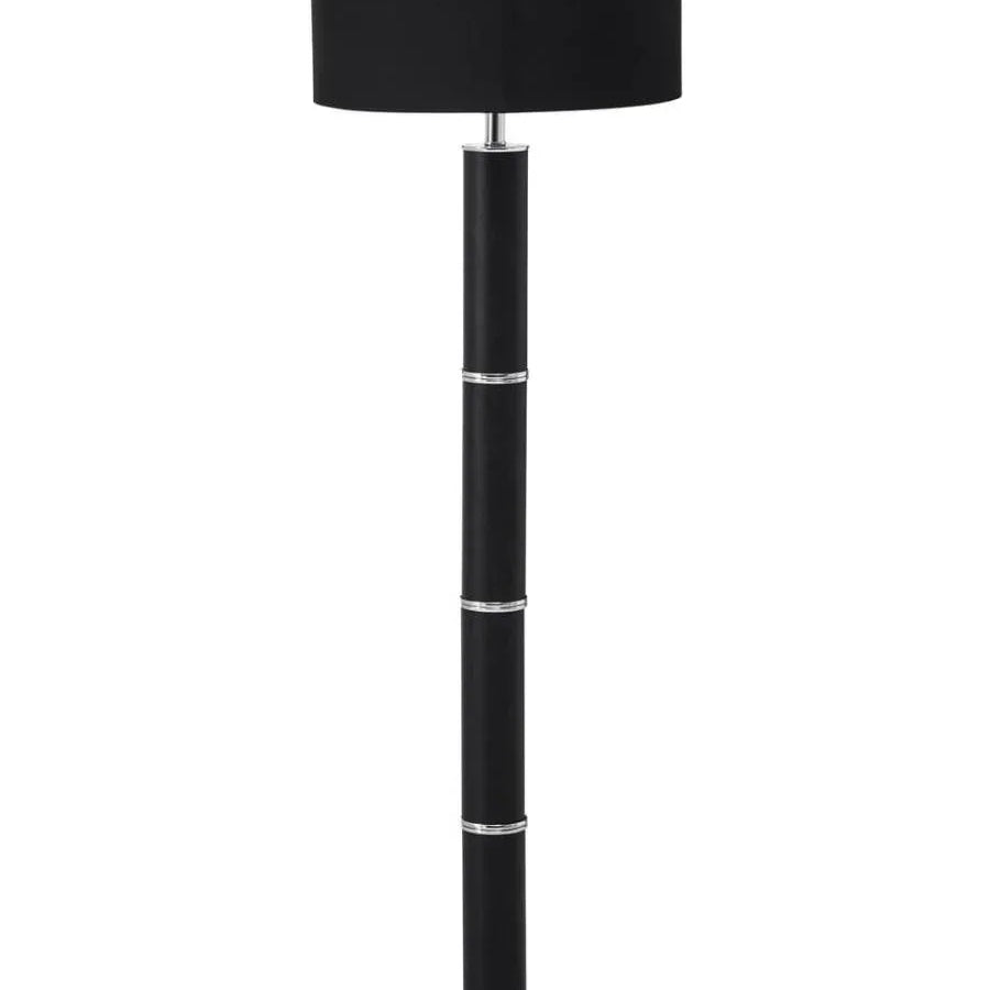 Black floor lamp with chrome accents and round base on white background