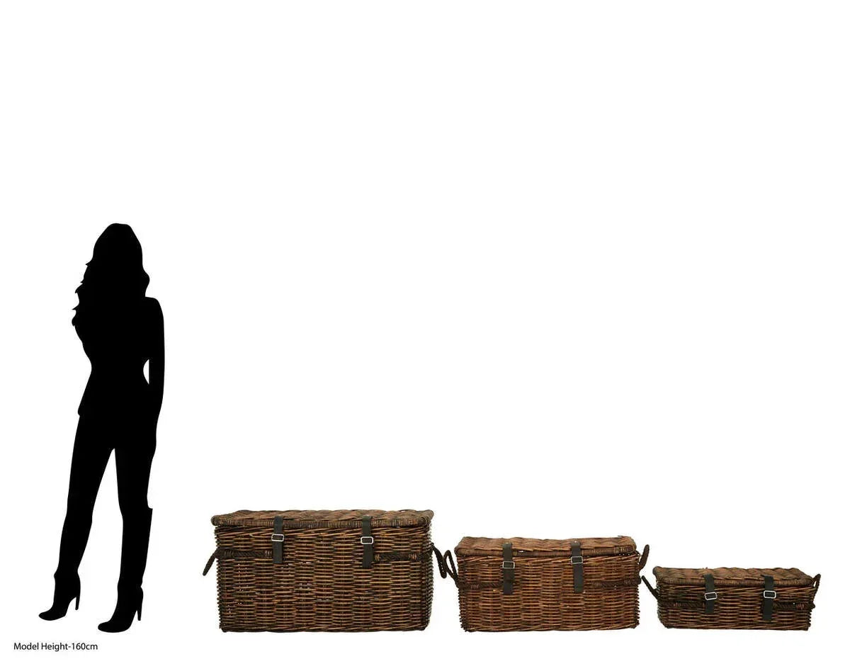 Three brown wicker storage trunks with leather straps in various sizes next to height silhouette