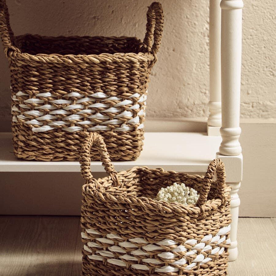 Square woven storage basket with handles, natural and white stripe, on wooden floor