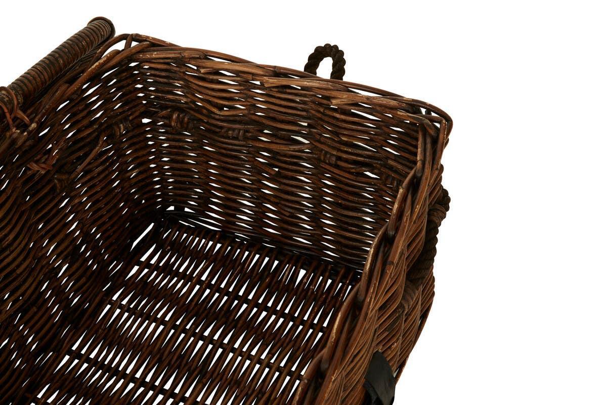 Brown wicker storage basket with handle and woven sides, close-up of interior corner