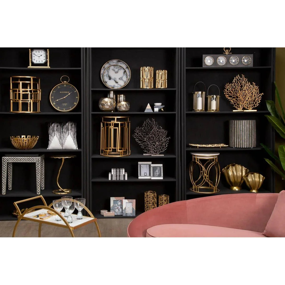 Black shelving unit with gold home decor, glass vases, and modern ornaments in living room