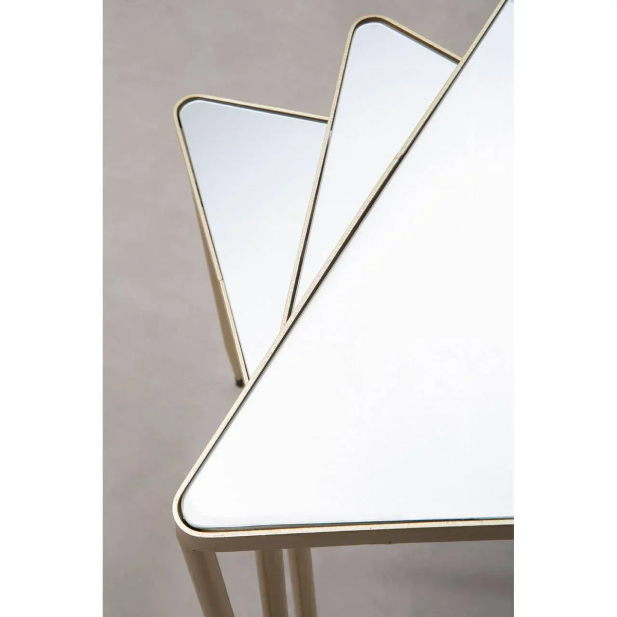 Set of three white glass nesting tables with gold metal frames, geometric triangular shape