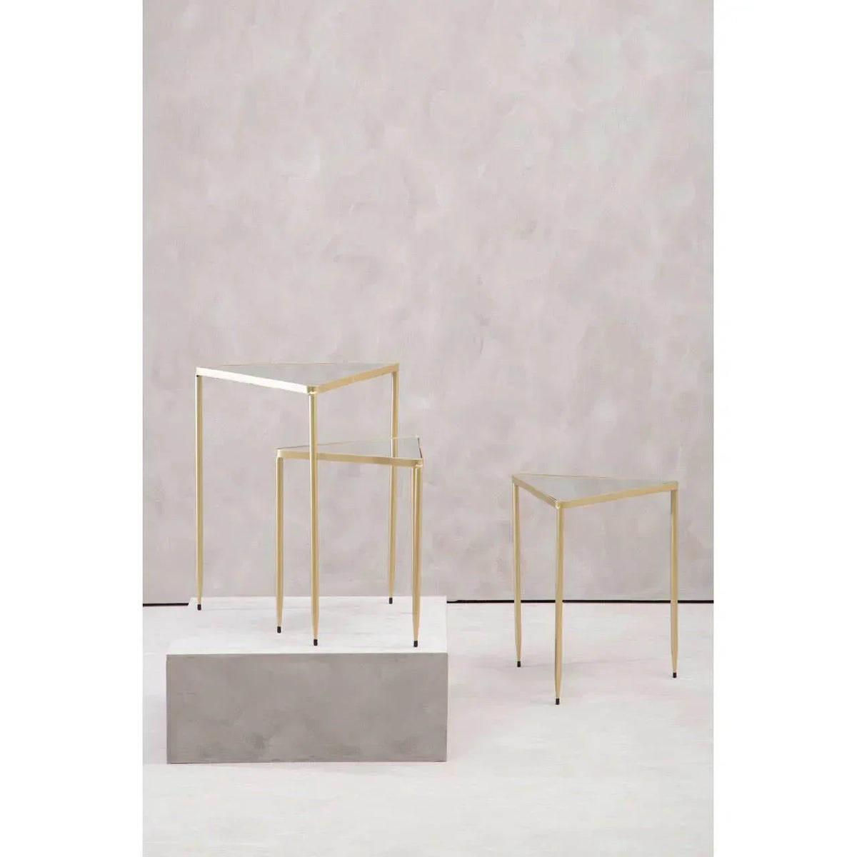 Set of three glass top side tables with slim gold metal frames in staggered heights
