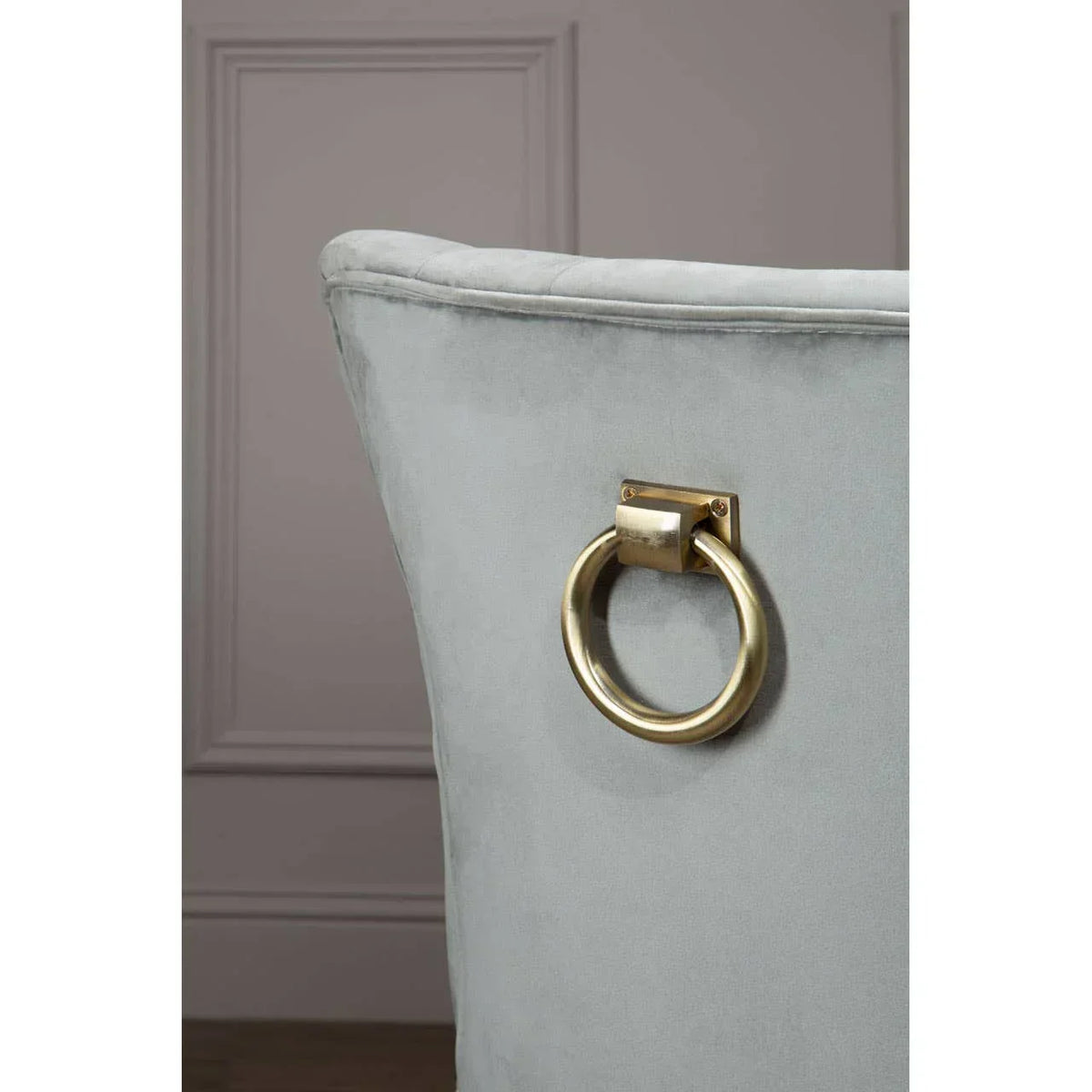 Light grey velvet dining chair back with gold metal knocker handle detail
